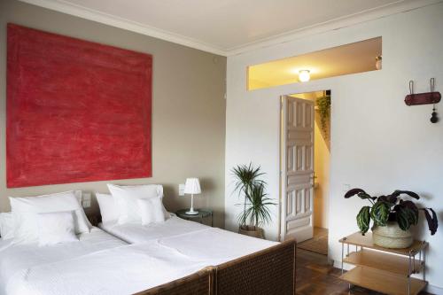 a bedroom with a large bed with a red painting on the wall at unic views begur, alojamiento turístico in Begur
