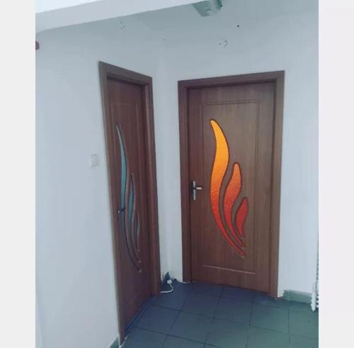 two wooden doors with a red fish painted on them at Apartment Mia's Home in Orşova
