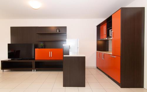 uma cozinha com armários laranja e preto em Lebic 411 in Marina Portoroz by Locap Group em Portorož