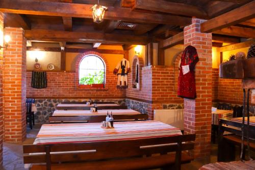 Семеен хотел Света Марина في دوبرينيشت: صف من الطاولات في غرفة بجدار من الطوب