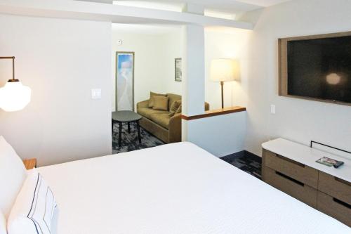 Fairfield Inn & Suites by Marriott Charleston Airport/Convention Center في تشارلستون: غرفه فندقيه بسرير واريكه