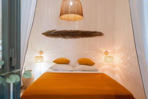 - un lit avec deux oreillers et une lampe à suspendre dans l'établissement T2 tout confort - Central- Bord de mer 100m - CLIM, à La Ciotat