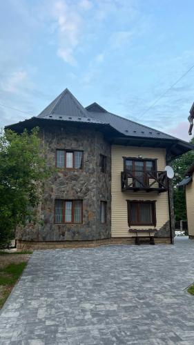 a stone house with a bench in front of it at Arkan in Mykulychyn