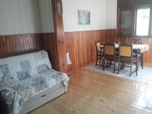 a living room with a couch and a table and chairs at Vila Trtović in Nova Varoš