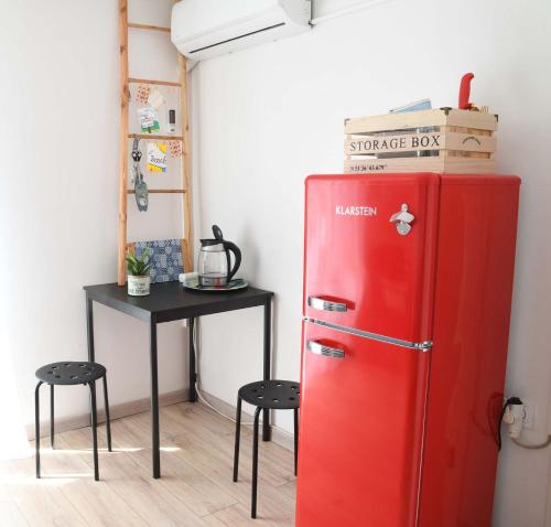 a red refrigerator in a room with a table at Vis-Rukavac-Retro room in Podstražje