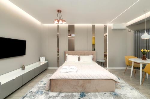 a bedroom with a bed and a tv and a table at Ely's Studio in Mamaia Nord