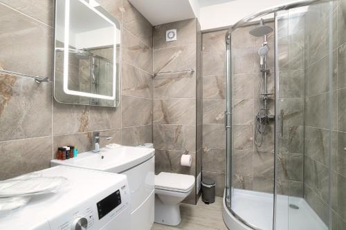 a bathroom with a shower and a toilet and a sink at Ely's Studio in Mamaia Sat/Năvodari