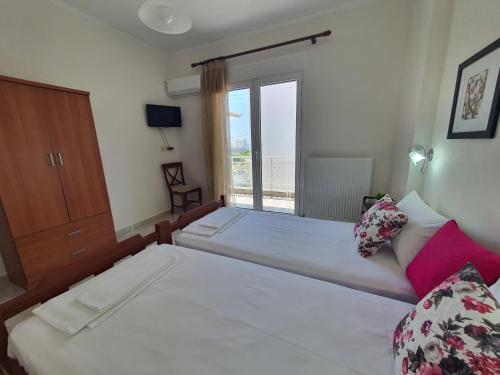 a bedroom with two beds and a window at Villa Evdokia in Limenaria