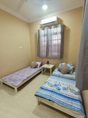 um quarto com 2 camas e uma janela em D' Terengganu Homestay em Kuala Terengganu