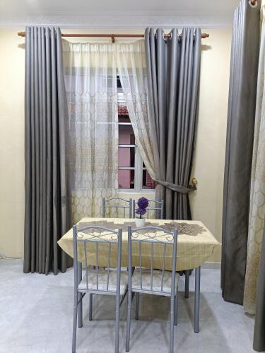 een eettafel met 2 stoelen en een raam bij D' Terengganu Homestay in Kuala Terengganu