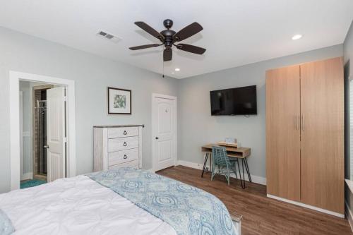a bedroom with a bed and a ceiling fan at "The Ocean Aire" , 30 secs from the sand! in Galveston