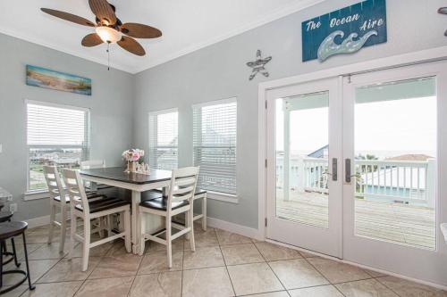 a dining room with a table and chairs and a ceiling fan at "The Ocean Aire" , 30 secs from the sand! in Galveston