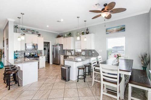 a kitchen with white cabinets and a ceiling fan at "The Ocean Aire" , 30 secs from the sand! in Galveston