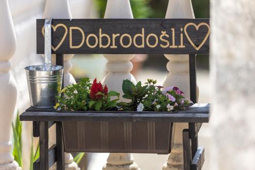 a sign on a rail with flowers on a table at Kuća za odmor Pixie in Vrsi