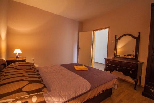 um quarto com uma cama, uma cómoda e um espelho em Apartments Nela em Zadar