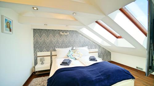 a bedroom with a large bed in a attic at Apartamenty Every Sky Kopernika 3 in Jelenia Góra