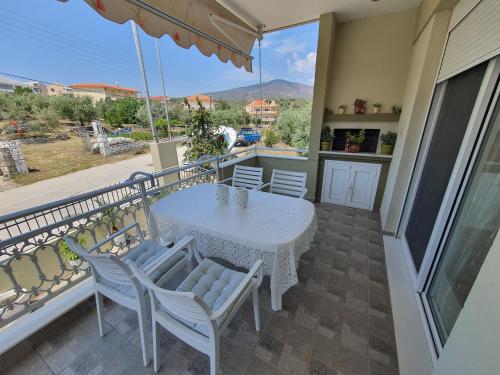 a table and chairs on a balcony with a view at Villa Evdokia in Limenaria