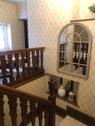 a room with a staircase with a mirror and a vase at The Skreen in Builth Wells