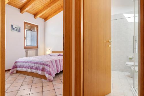 ein Schlafzimmer mit einem Bett und ein Badezimmer mit Dusche in der Unterkunft Rustico Spagnol 4 in Tignale