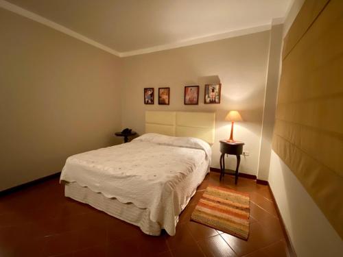 1 dormitorio con 1 cama y 1 mesa con lámpara en Posada El Remanso de Pueblo Nuevo, en San Cristóbal