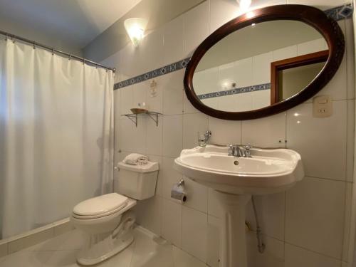 a bathroom with a toilet and a sink and a mirror at Posada El Remanso de Pueblo Nuevo in San Cristóbal