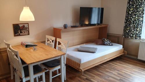 Kleines Zimmer mit einem Bett und einem Tisch in der Unterkunft Ferienwohnungen am Neuen Markt in Einbeck