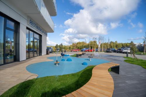 un edificio con piscina frente a un edificio en POLANKI AQUA APARTMENTS en Kołobrzeg