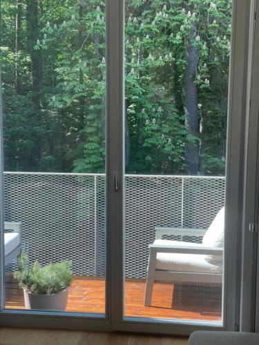 a sliding glass door with a view of a patio at Sunny apartment with forest view in Juodkrantė