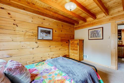 a bedroom with wooden walls and a bed in a room at Mountain Views on the 45th Parallel in New Meadows