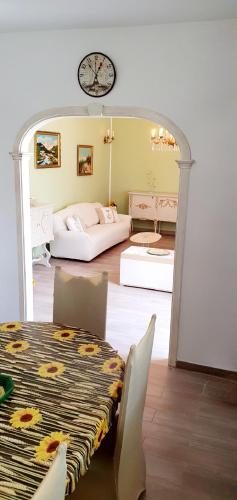 a room with two beds and a table and a clock at Agape casa vacanze in Giardini Naxos