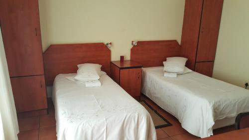 - 2 lits dans une chambre avec des draps blancs dans l'établissement Deletz Guesthouse, à Witbank