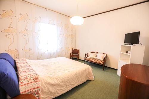 1 dormitorio con 1 cama, TV y silla en GlampingCashmereHause, en Rivotorto