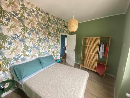 ein Schlafzimmer mit einem Bett mit einer tropischen Tapete in der Unterkunft Casa Vacanze Nene in Minturno