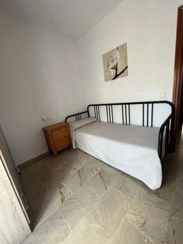 a bedroom with a bed and a dresser in a room at Huerto Apartment in Lucena
