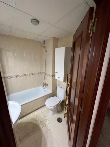 La salle de bains est pourvue de toilettes, d'une baignoire et d'un lavabo. dans l'établissement Huerto Apartment, à Lucena