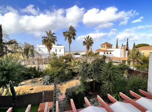 a view from the roof of a house with palm trees at SibsSanlucar Donana 1ª Línea Playa-Piscina-Padel in Sanlúcar de Barrameda