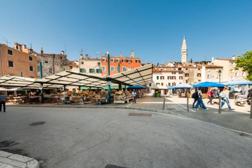 a group of people walking around a market with umbrellas at Revera Rooms in Rovinj