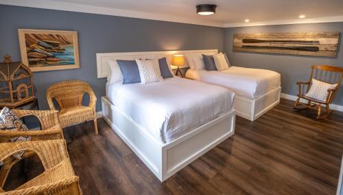 sypialnia z 2 łóżkami, stołem i krzesłami w obiekcie Lighthouse Motel and Cottages w mieście Bridgewater