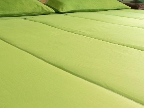 a green bed with two green pillows on it at B&B Le Colonne in Montefusco