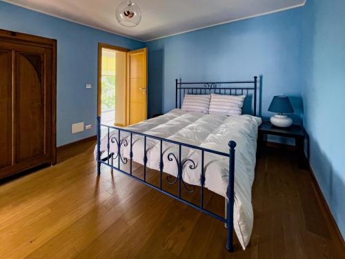 een slaapkamer met een bed met een blauwe muur bij La Casetta Gialla in Biella