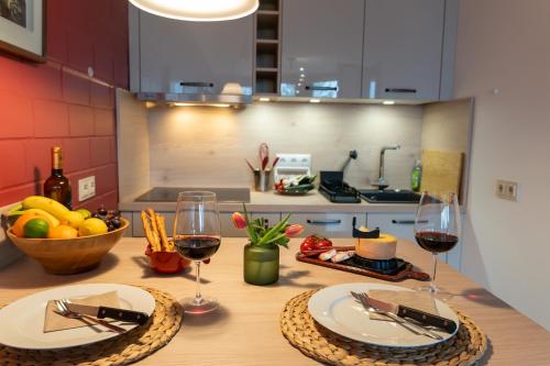 a table with two glasses of wine and a bowl of fruit at FeWo Harzer Weitblick Hunde Willkommen, W Lan, 2x Smart TV in Braunlage