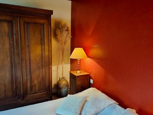 a bedroom with a bed with a lamp on it at La ferme des douceurs in Cervon