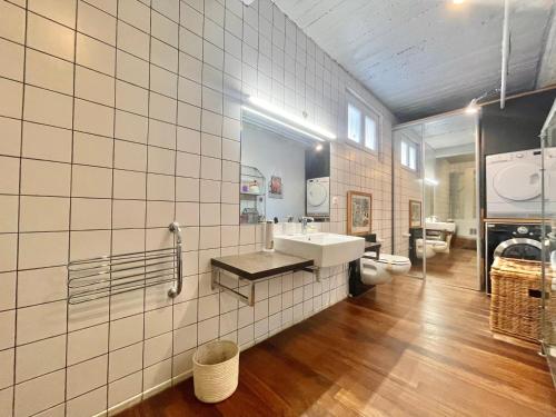 La salle de bains est pourvue d'un lavabo et d'un mur carrelé blanc. dans l'établissement Souvenir à jamais !, à Nice