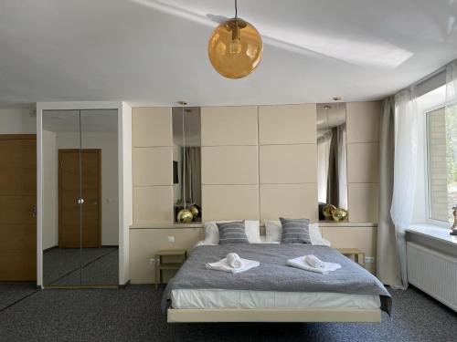 Hotel "Senleja" في سيغولدا: غرفة نوم عليها سرير وفوط