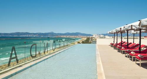 a swimming pool with chairs and umbrellas on a beach at Pure Salt Garonda - Adults Only in Playa de Palma