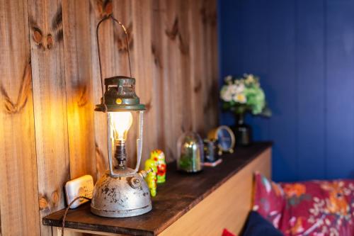 a lantern is sitting on a wooden table at Under the Oak Glamping in Caerphilly