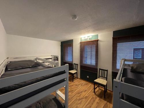 a bedroom with two bunk beds and two chairs at Bodensee Apartments in Friedrichshafen