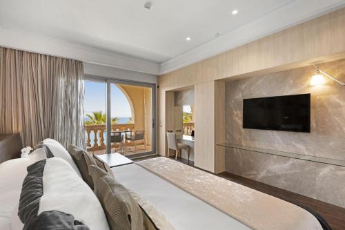 a hotel room with a bed and a flat screen tv at Pure Salt Port Adriano - Adults Only in Santa Ponsa