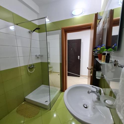 ein Bad mit einem Waschbecken und einer Glasdusche in der Unterkunft Studio by the beach - Vlore in Vlorë