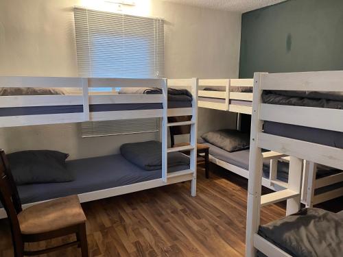 a room with three bunk beds and a chair at Bodensee Apartments in Friedrichshafen